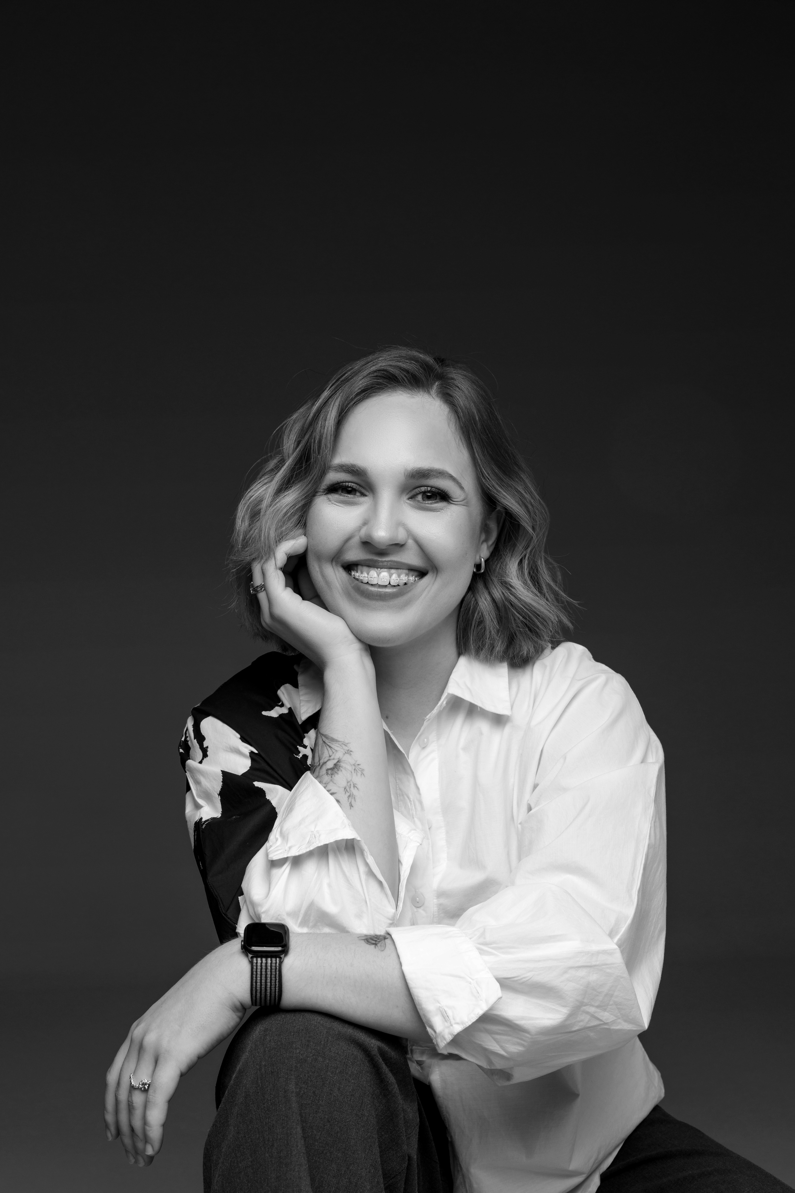 photo of yuliia kucherenko sitting and smiling to the camera, black and white